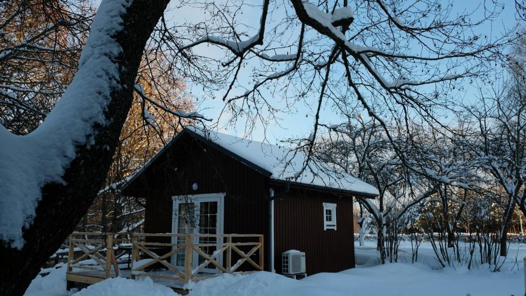 a red barn with snow on top of it at Namelis Šiaurėje in Kaltanėnai
