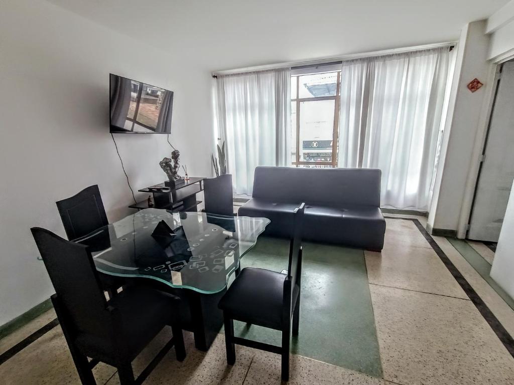 a living room with a glass table and a couch at Apartamento Agradable sector Céntrico de la Ciudad Casa Loma in Armenia