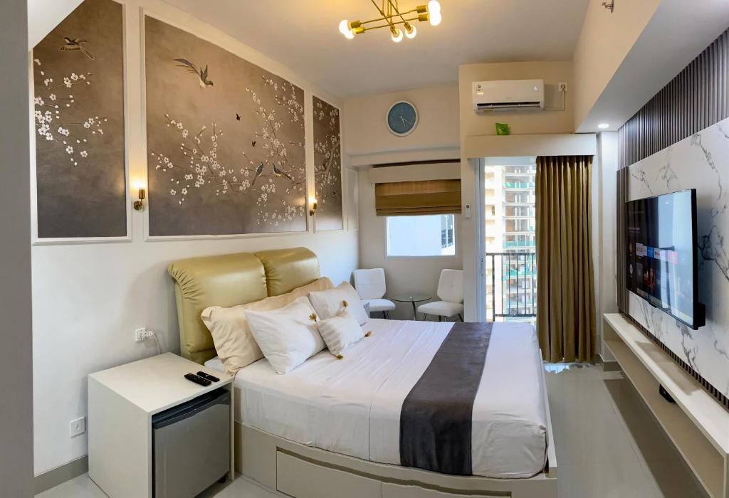 a bedroom with a large bed and a television at Parkland Avenue Serpong BSD by Owner in Babakan