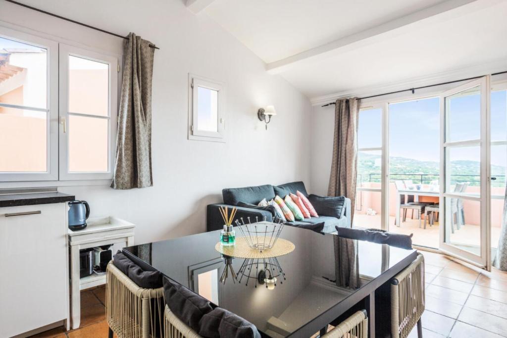 une cuisine et un salon avec une table et des chaises dans l'établissement Les Bastides aux Restanques du Golfe de St Tropez - maeva Home - Bastide 3 pièces 6 personnes avec splendide vue mer - Prestige - Super Home MAE-2257, à Grimaud