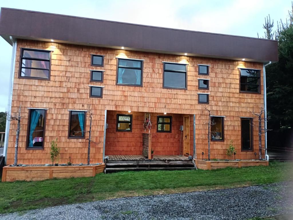 een groot bakstenen huis met verlichting bij CABAÑAS RAYEN HUILLINCO in Chonchi