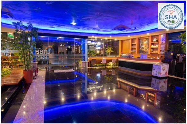 a lobby with a bar with blue lights on the floor at Marlin Hotel in Suratthani