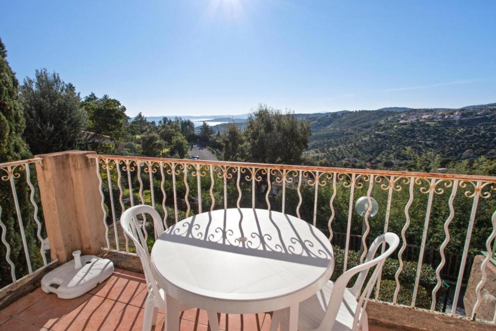 une table blanche et des chaises sur un balcon dans l'établissement Les Issambres Corniche - maeva Home - Appartement 2 pièces 6 personnes Sélection MAE-1357, aux Issambres