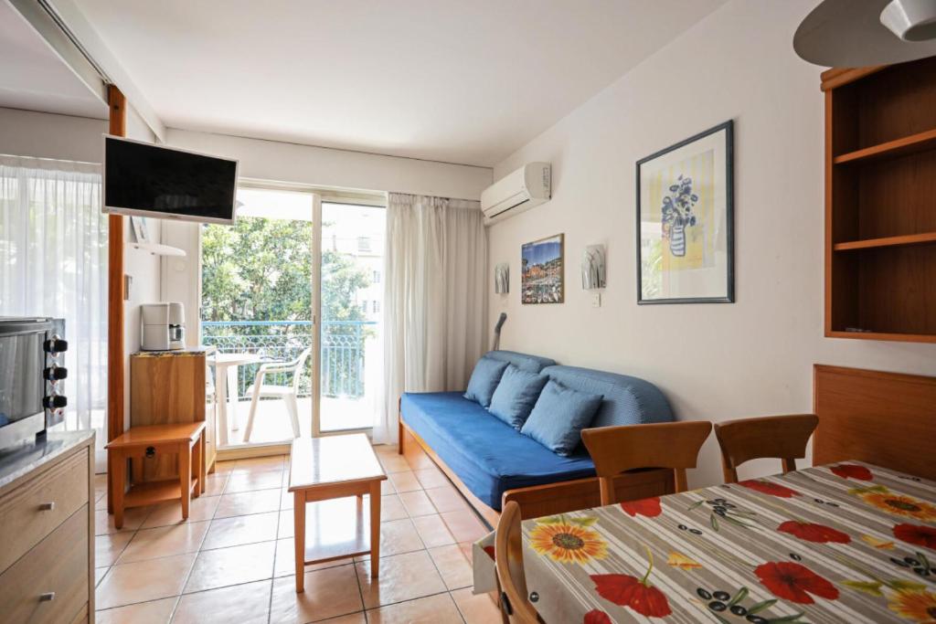 un salon avec un canapé bleu et une table dans l'établissement Résidence les Rivages du Parc - maeva Home - Studio 5 personnes - Confort MAE-0812, à Menton