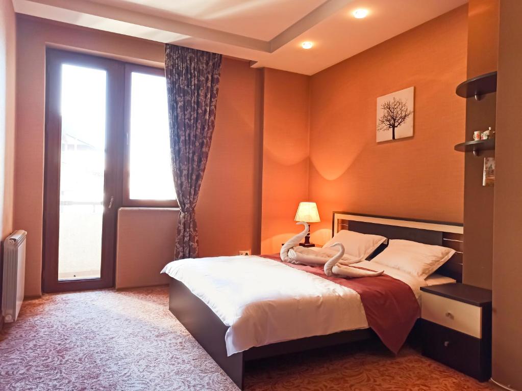 een slaapkamer met oranje muren en een bed en een raam bij A paradise for large groups in Tbilisi City
