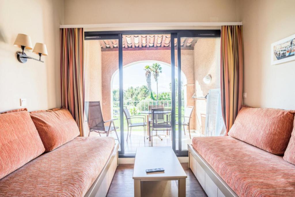 un salon avec un canapé et une table dans l'établissement Résidence Les Parcs de Grimaud - maeva Home - Studio 4 Personnes - Confort MAE-0281, à Grimaud