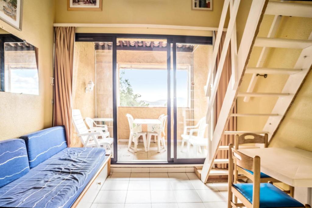 Cette chambre dispose d'un lit et d'un balcon avec une table. dans l'établissement Résidence Les Parcs de Grimaud - maeva Home - Studio 5 Personnes - Confort MAE-0295, à Grimaud