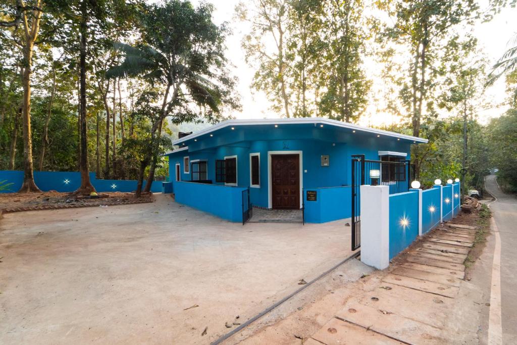 ein blaues Haus mitten auf einem Parkplatz in der Unterkunft Stefleena's Nest in Loutolim