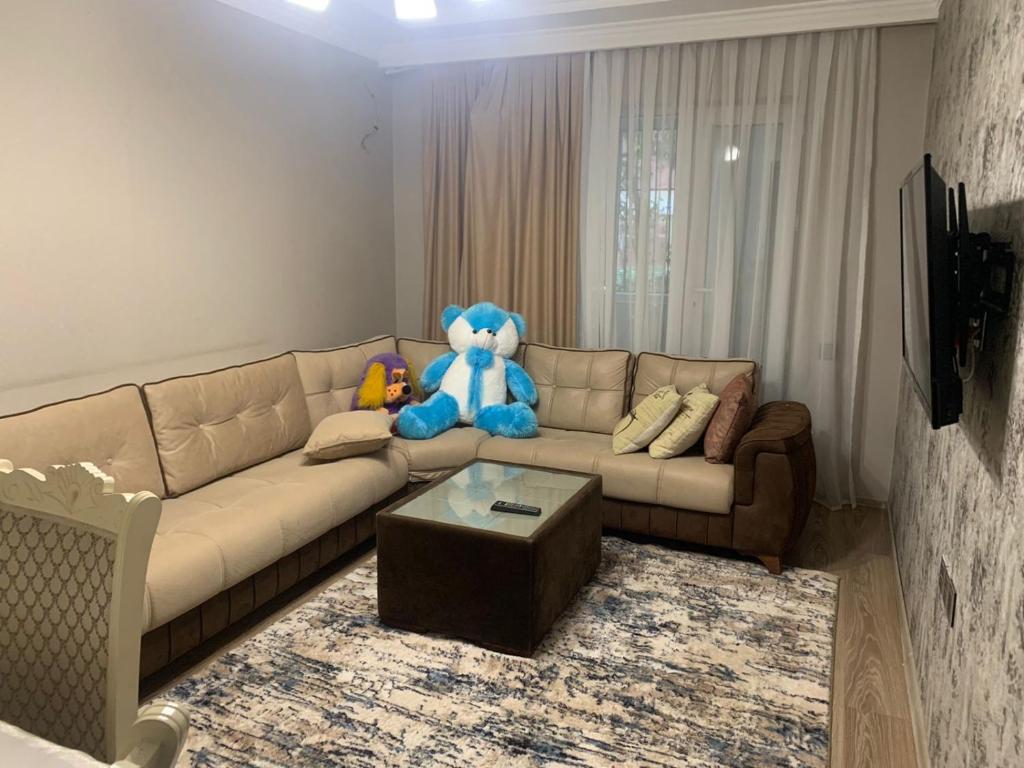 a living room with a couch with a teddy bear on it at Dream Home in Baku