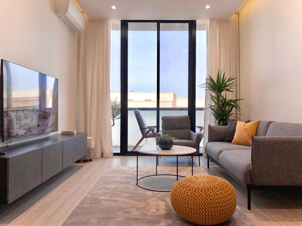 ein Wohnzimmer mit einem Sofa und einem TV in der Unterkunft Inbar Residence إنبار ريزدينس شقة عائلية متكاملة in Riad