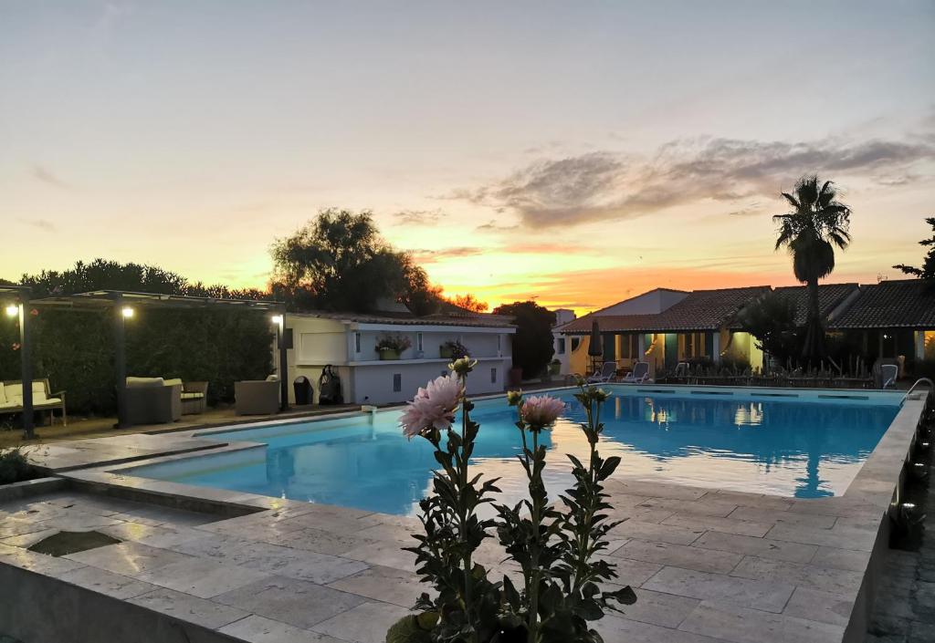 een villa met een zwembad bij zonsondergang bij L'auberge Camarguaise in Saintes-Maries-de-la-Mer