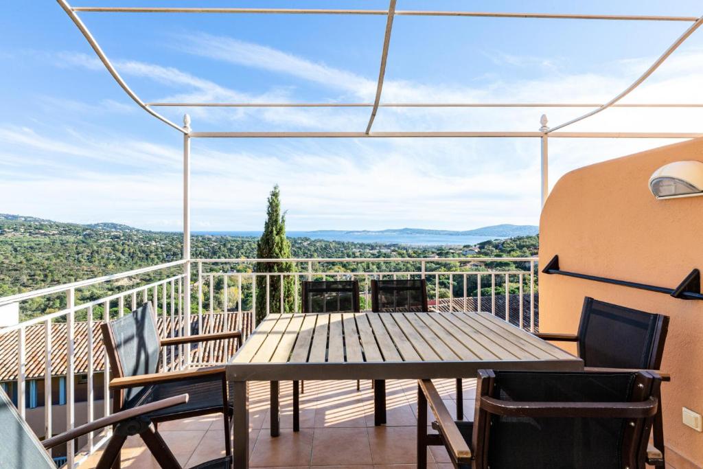 d'une terrasse avec une table et des chaises sur un balcon. dans l'établissement Les Appartements aux Restanques du Golfe de St Tropez - maeva Home - Appartem 04, à Grimaud