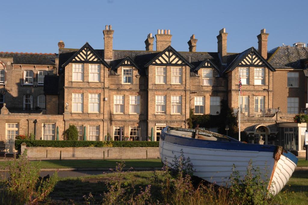 a boat sitting in front of a large building at Wentworth Hotel in Aldeburgh