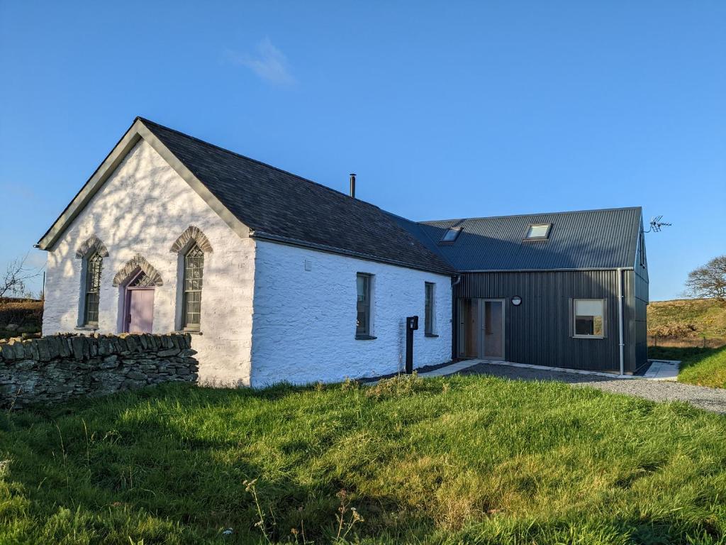 a white church with a black roof at Ysgoldy Brynwyre in Llanrhystyd