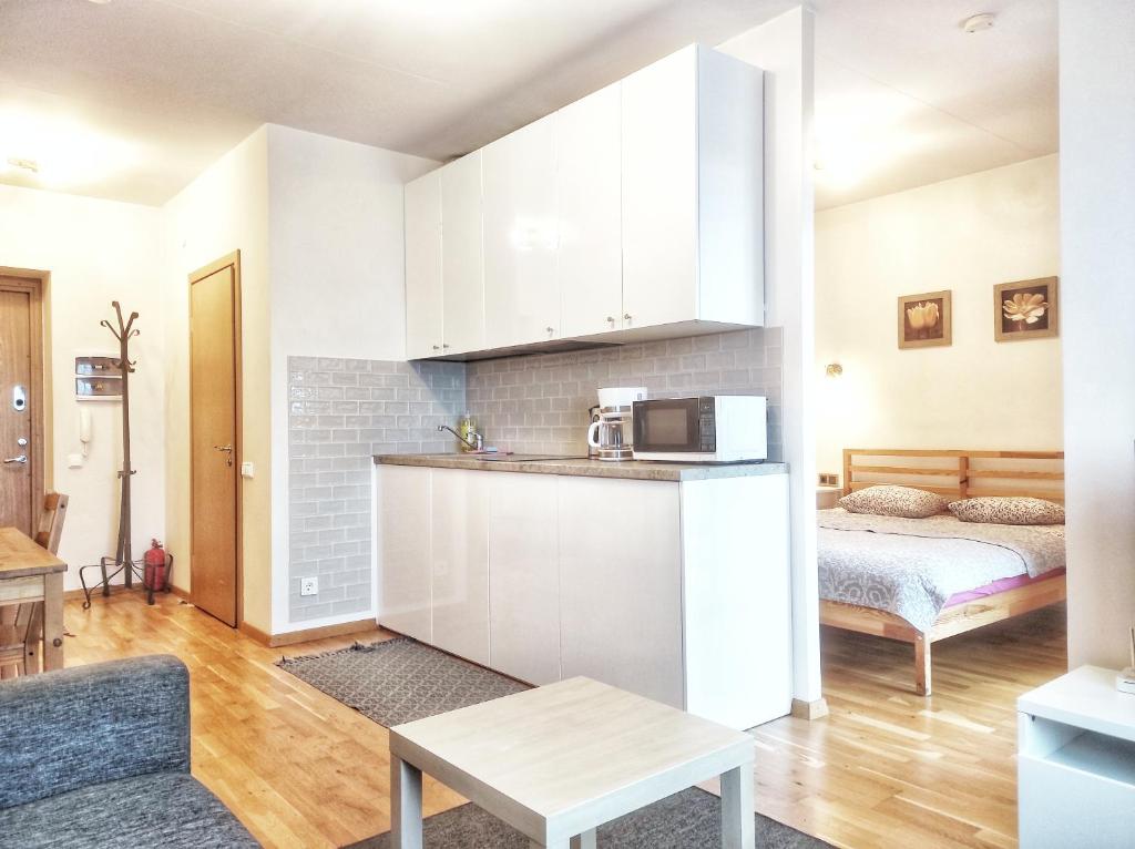 a living room with a kitchen and a bed at Lovely Dream Apartment in Vilnius