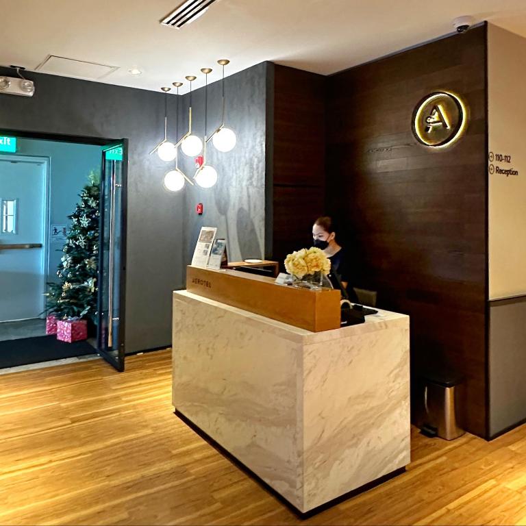 a woman sitting at a counter in a lobby at Aerotel Cebu in Mactan