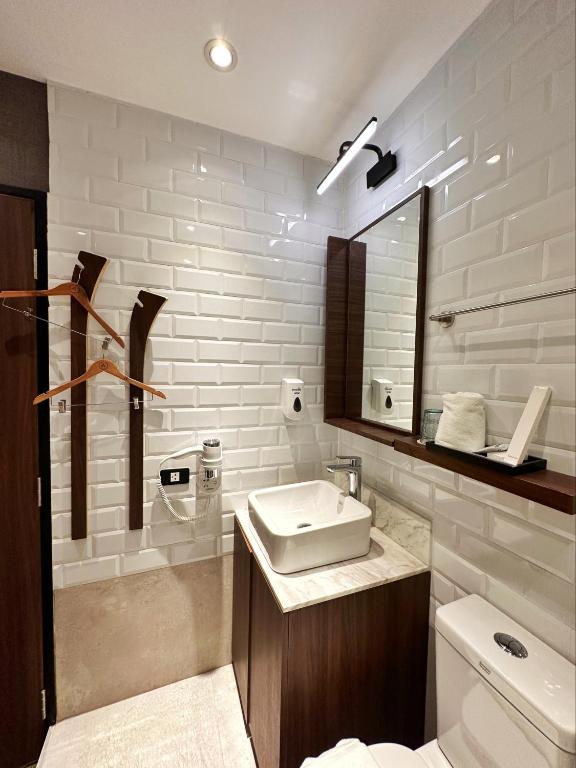 a bathroom with a sink and a toilet and a mirror at Aerotel Cebu in Mactan