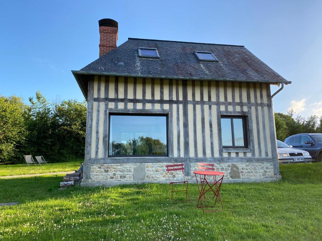 une maison avec deux chaises devant elle dans l'établissement Maisonnette au calme, 15 kms Honfleur/Deauville, à Les Authieux-sur-Calonne