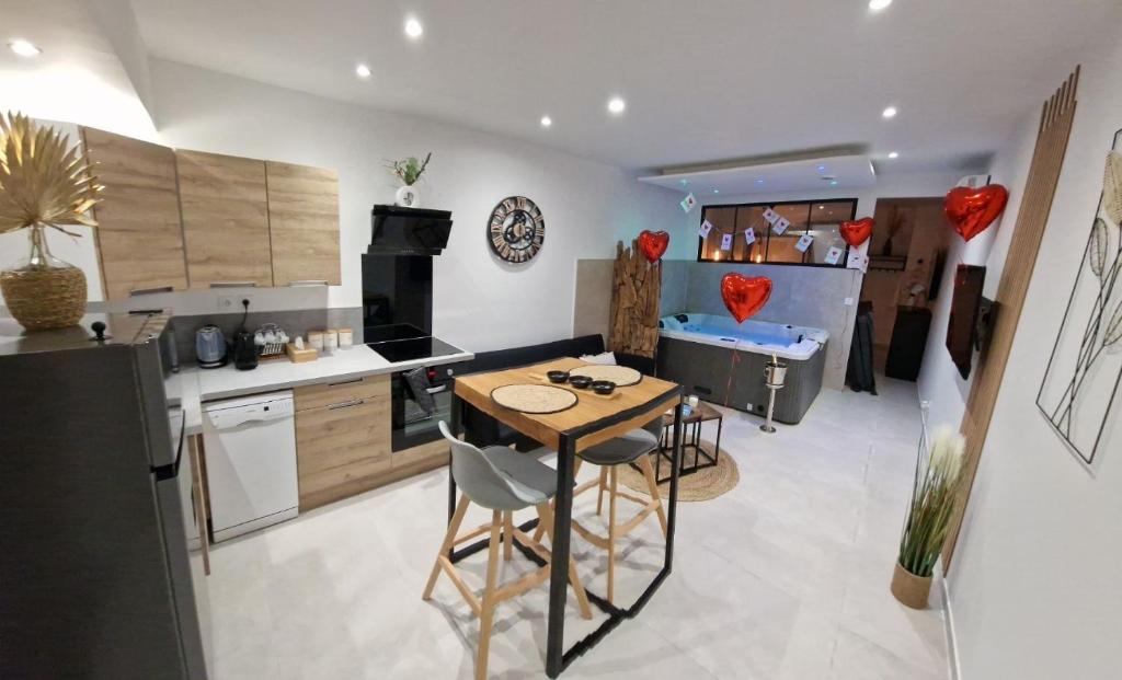 eine Küche mit einem Tisch und Stühlen im Zimmer in der Unterkunft Appartement - Spa in Monteux