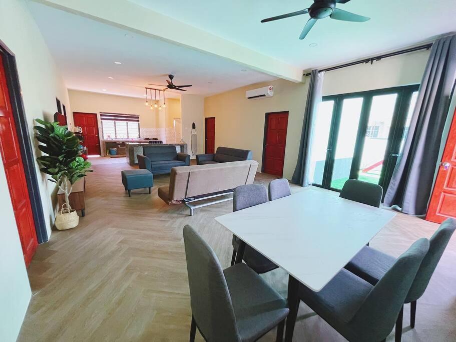 Una sala de estar con una mesa y sillas blancas. en Villa D'Razna - Luxury 5-bedroom Villa with private pool, en Kuala Terengganu
