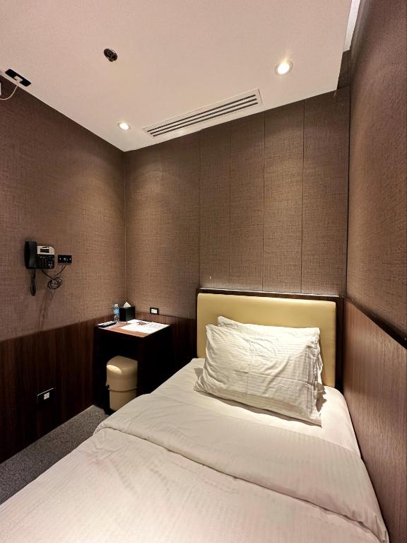 a bedroom with a bed and a nightstand and a bed sidx sidx sidx sidx at Aerotel Cebu in Mactan