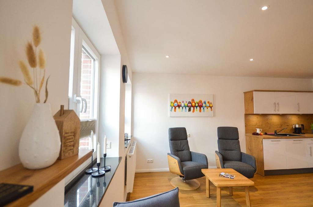 a living room with two chairs and a table at Alte Uhrmacherei - Wohnen auf Zeit in Aurich