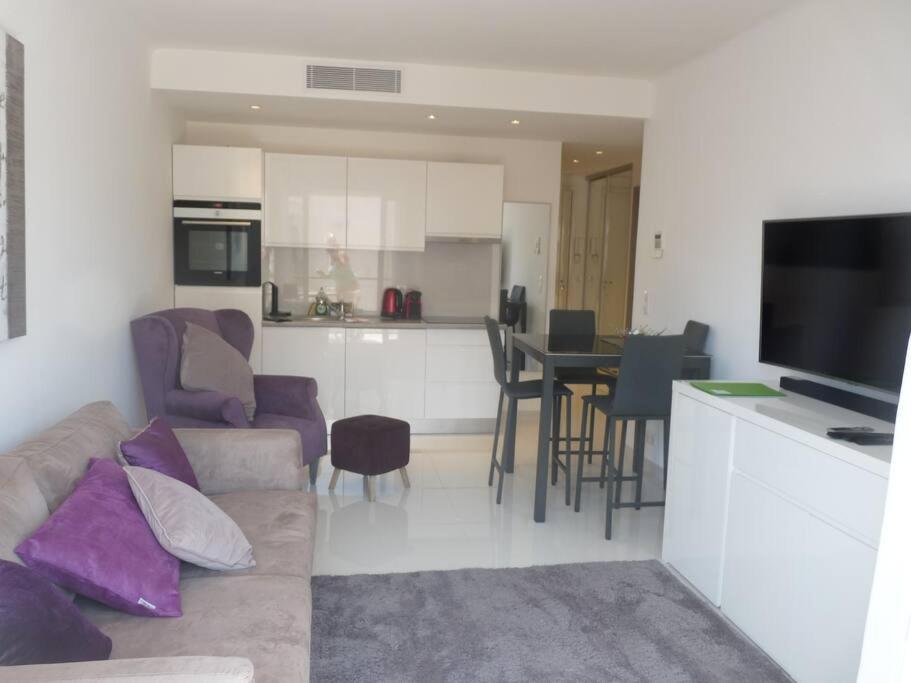 un salon et une cuisine avec un canapé et une table dans l'établissement Two bedroom apartment next to the Croisette in Cannes a short walk to the Palais des Festivals - 1961, à Cannes