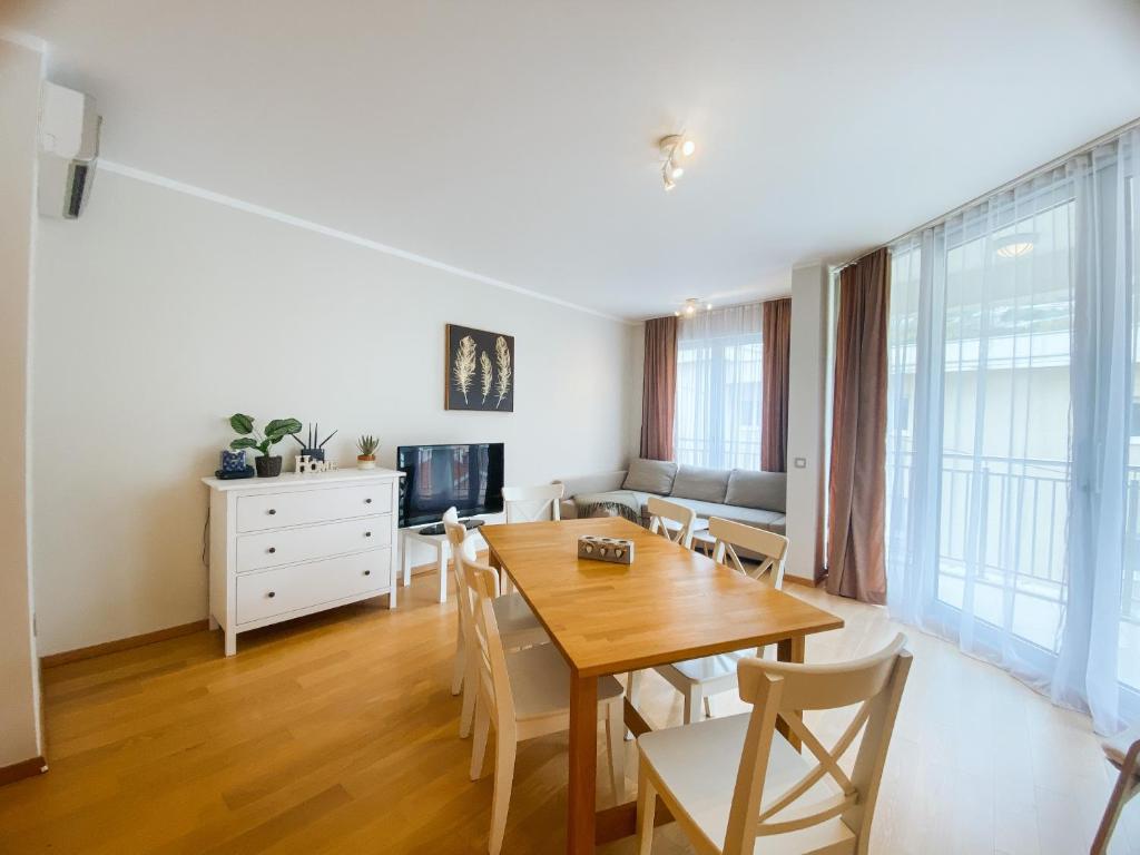 a dining room with a wooden table and chairs at Sunny apartment in Bečići