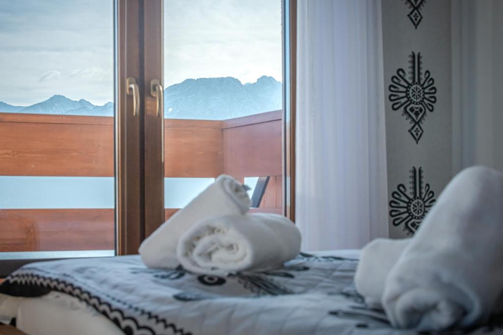 a bedroom with a bed with a view of a window at Willa na Grani in Zakopane