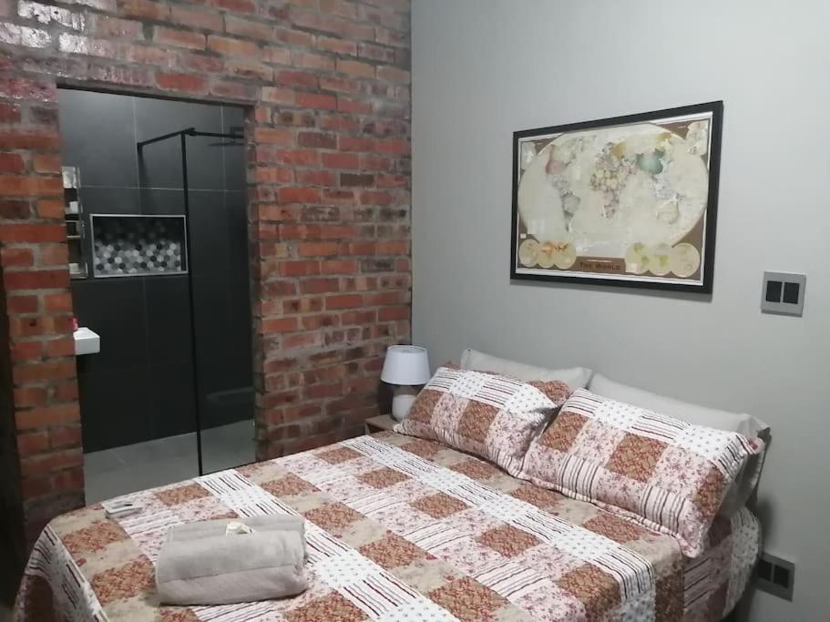 um quarto com uma cama e uma parede de tijolos em Platform 162 em Cidade do Cabo