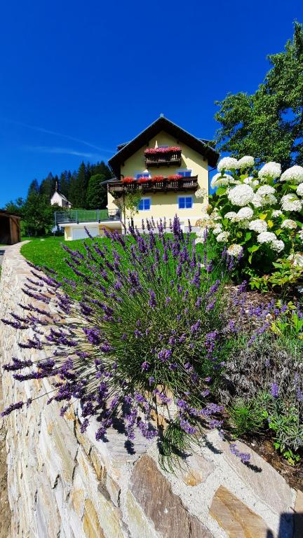 a garden with flowers in front of a building at Kalvarienberg Appartement Gosau in Gosau