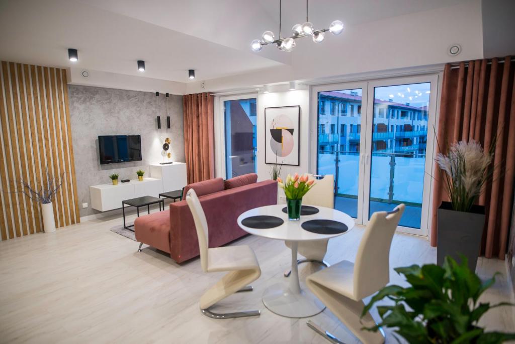 sala de estar con sofá y mesa en Nowoczesny apartament z antresolą i garażem, en Biskupiec