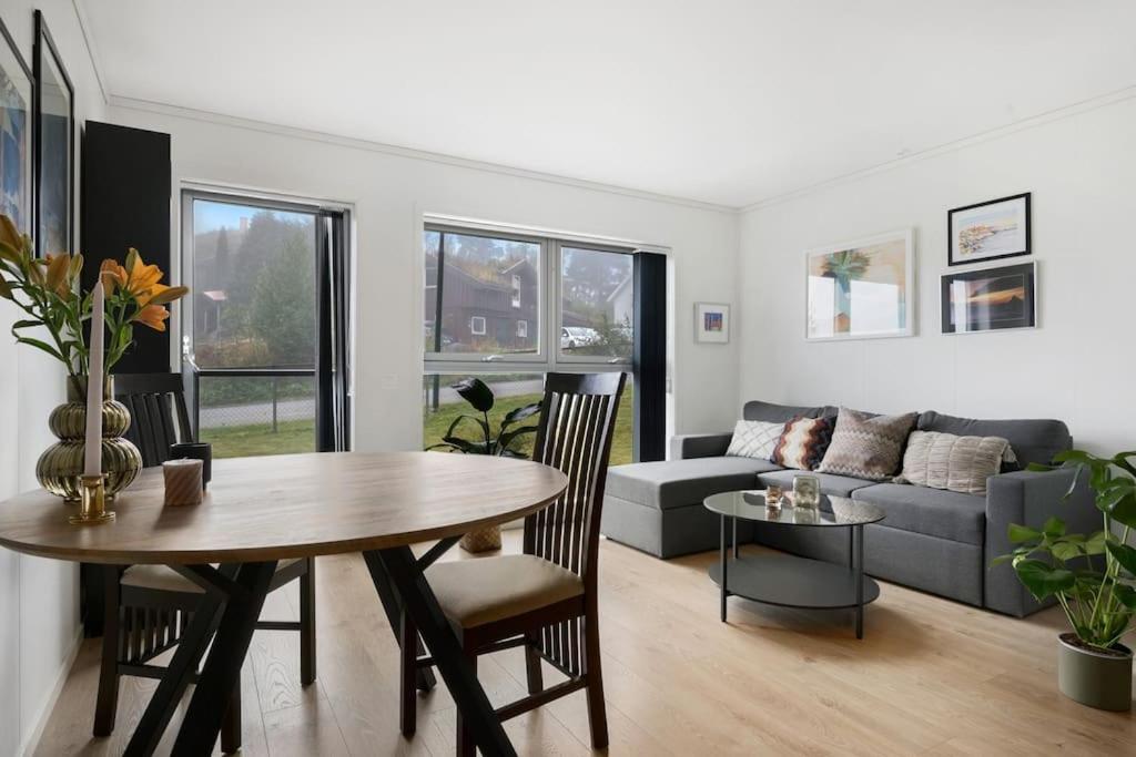 een woonkamer met een tafel en een bank bij Moderne leilighet - nært flyplass - lader for elbil in Råholt
