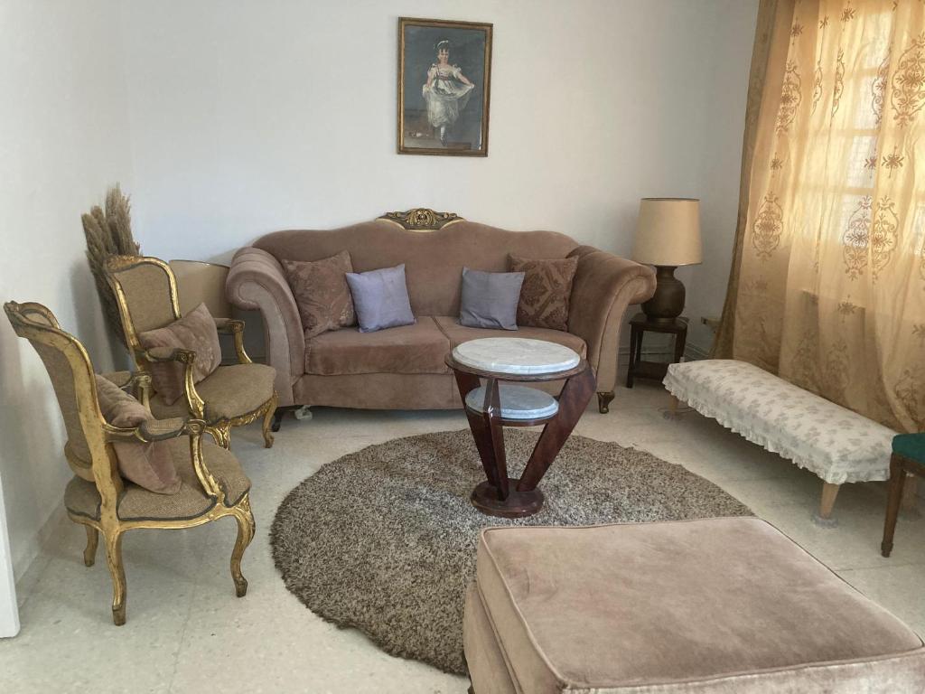 a living room with a couch and a table and chairs at Maison Avec Jardin Garage in La Marsa