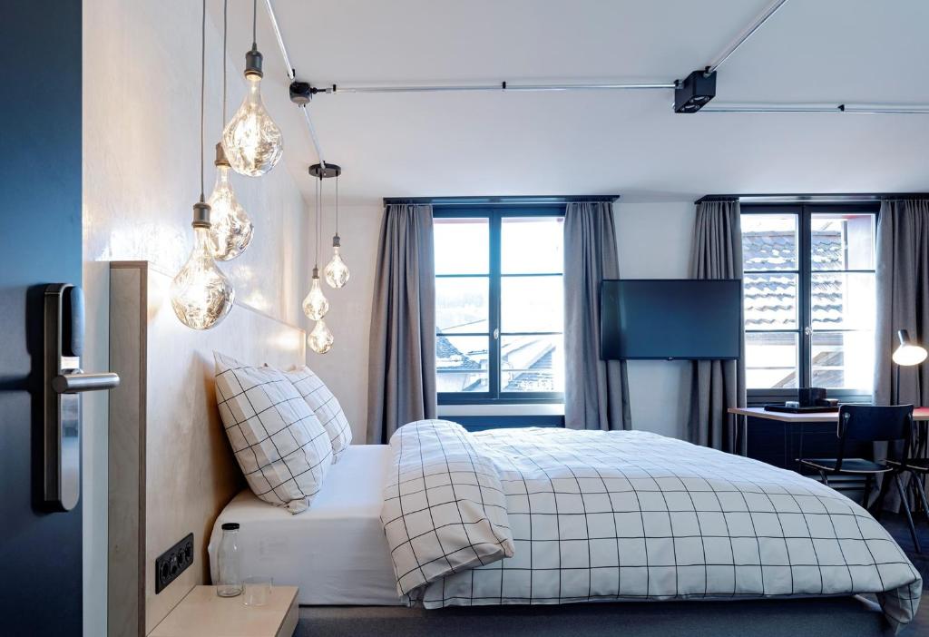 Schlafzimmer mit einem Bett, einem Schreibtisch und Fenstern in der Unterkunft The Lubo - self check-in in Luzern