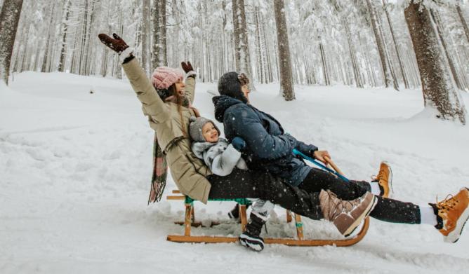 a group of people riding on a sled in the snow at OREA Spa Hotel Bohemia Mariánské Lázně in Mariánské Lázně
