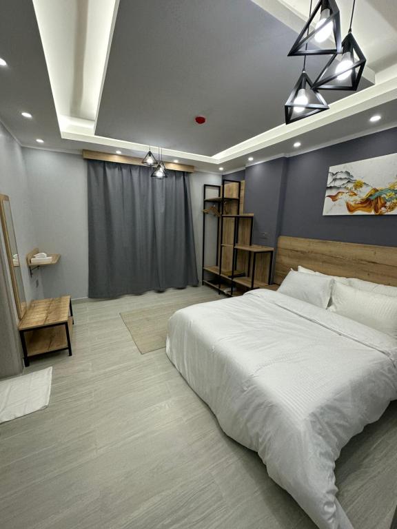1 dormitorio con 1 cama blanca grande en una habitación en Blue Rose Hotel en Al Amarat