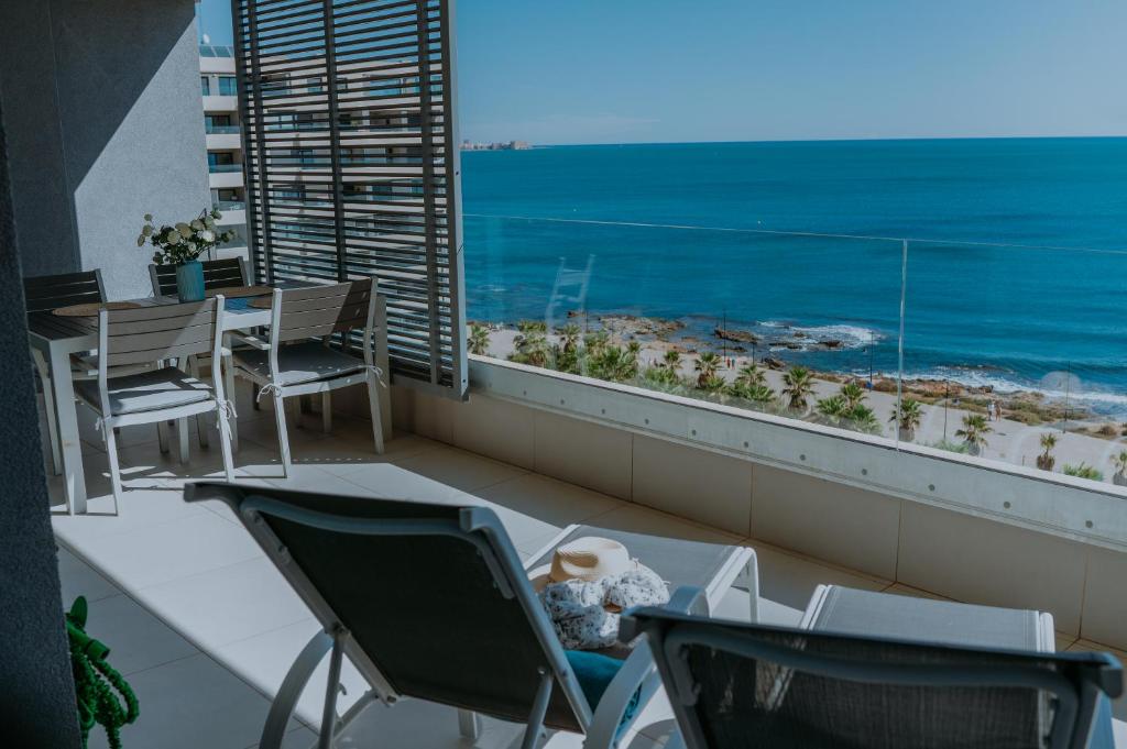 a balcony with a table and chairs and the ocean at Panorama Mar Apartment in Punta Prima