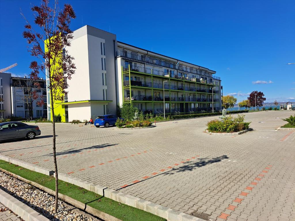 a parking lot in front of a large building at Silver Apartman in Siófok