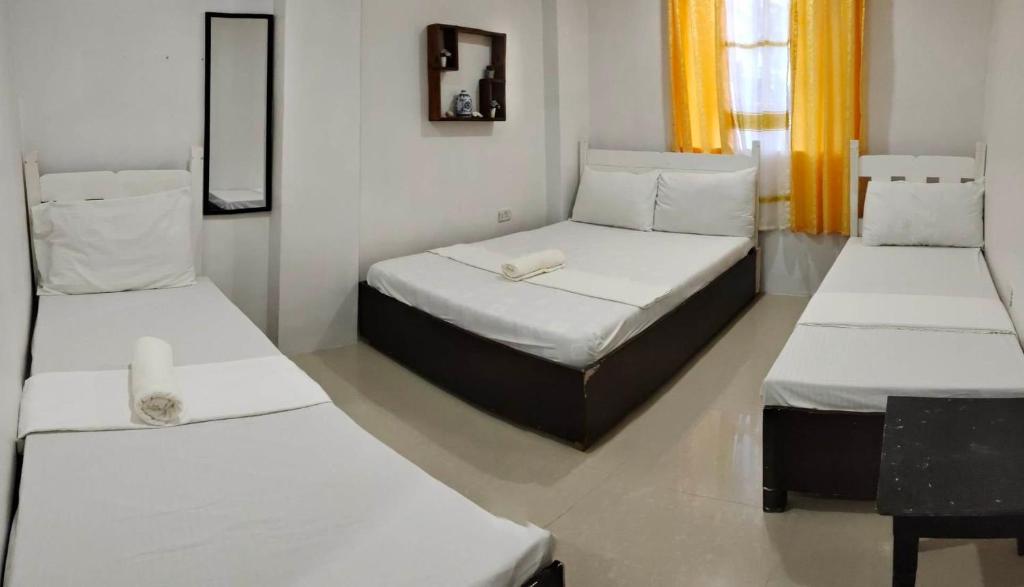 um quarto com duas camas e um espelho em Island Hop Inn em El Nido