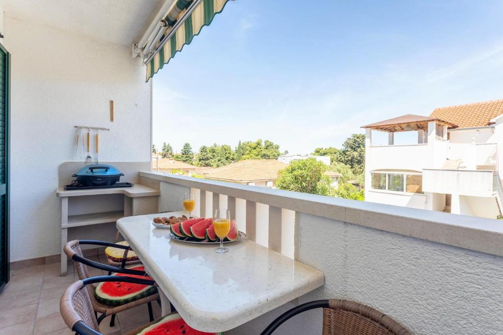 Un balcón con una mesa con un bol de fruta. en Apartment Zara Supetar, en Supetar