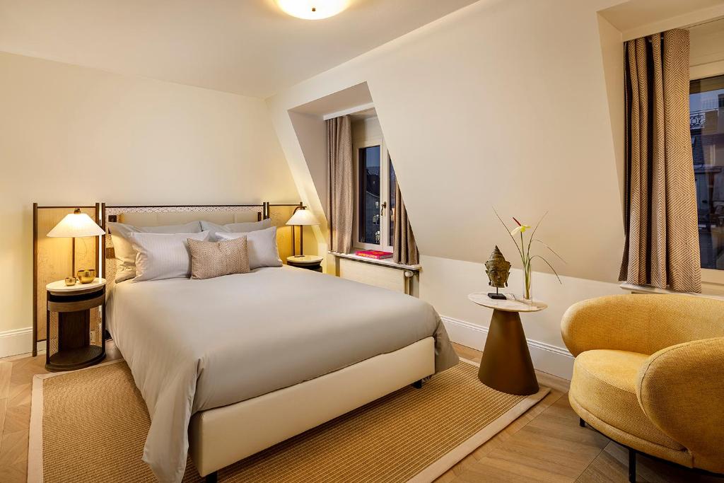 a hotel room with a bed and a chair at Small Luxury Hotel Ambassador Zurich in Zürich