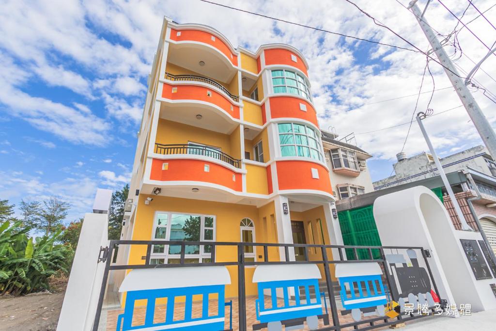 um edifício colorido com uma cerca em frente em Tie Zhi Road B&B em Taitung City