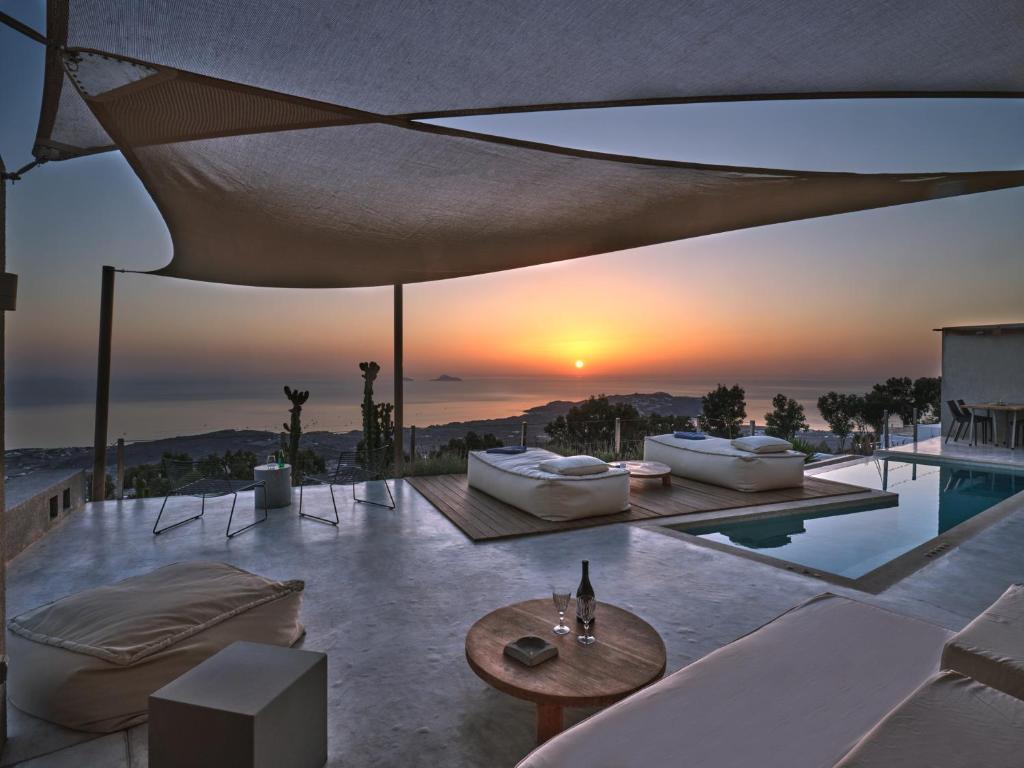 una sala de estar con vistas a la puesta de sol. en Santorini Heights, en Pirgos