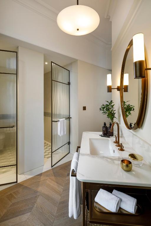 a bathroom with a sink and a mirror at Small Luxury Hotel Ambassador Zurich in Zürich