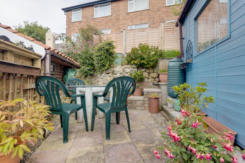 d'une terrasse avec 2 chaises vertes et une table. dans l'établissement Charming Historical Cottage in Scarborough, à Scarborough