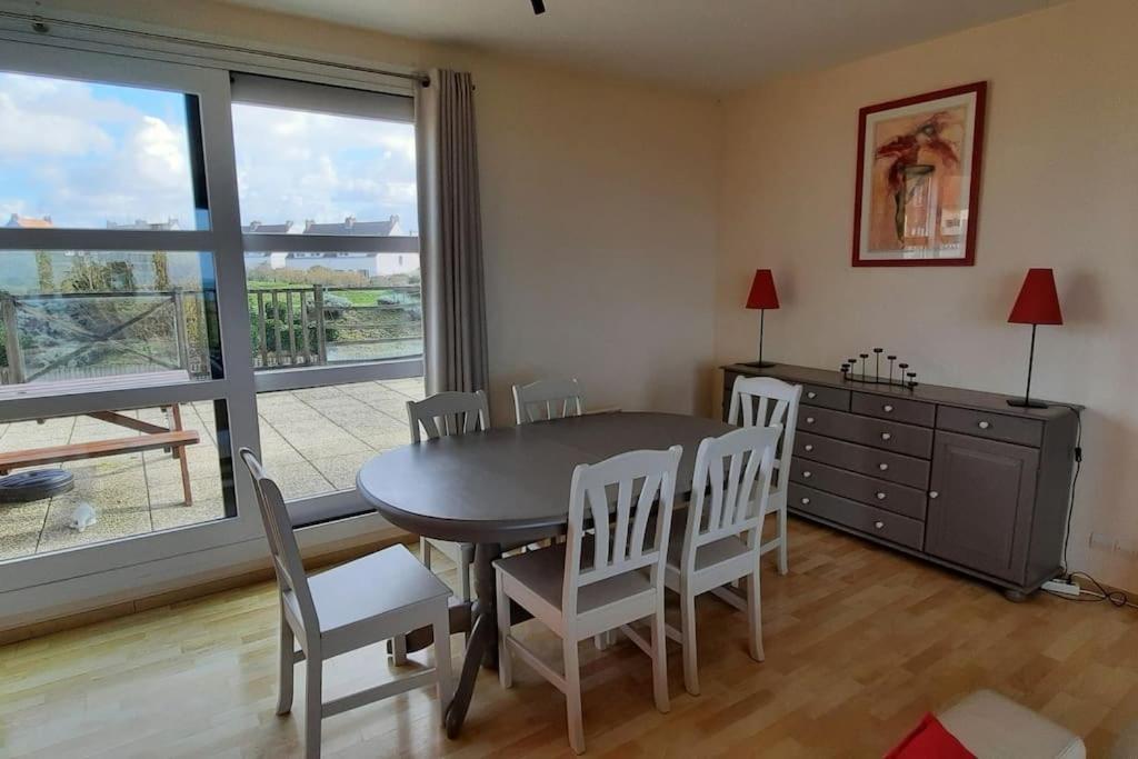 een eetkamer met een tafel en stoelen en een raam bij exceptionnel penthouse vue mer in Wimereux