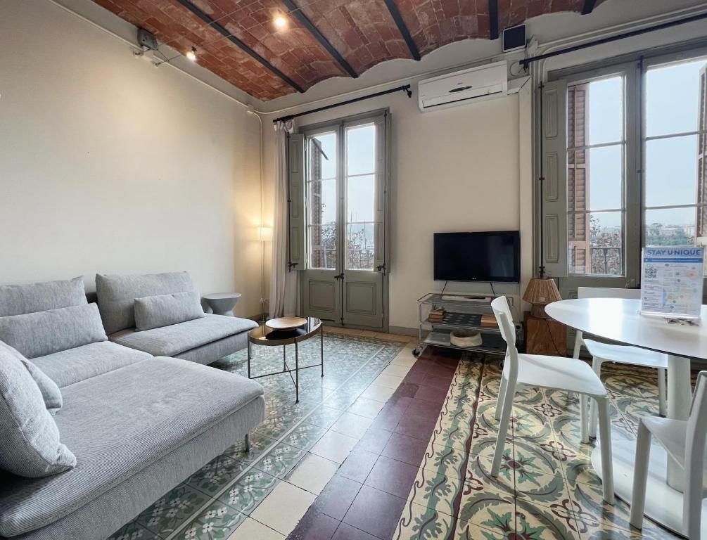 ein Wohnzimmer mit einem Sofa und einem Tisch in der Unterkunft Stay U-nique Apartments Borbó II in Barcelona