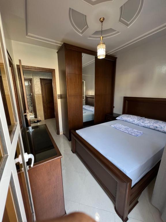 a bedroom with a bed and a mirror at Appartement boulaàyoun de luxe à louer nador 3 in Nador