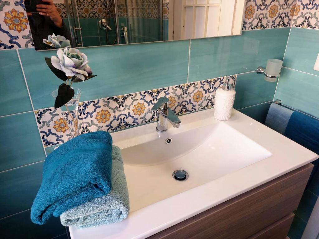 umywalkę w łazience z niebieskim ręcznikiem w obiekcie B&B ANTONIETTA w mieście Vico Equense